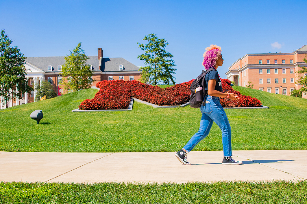 Person walking in front of the "M".