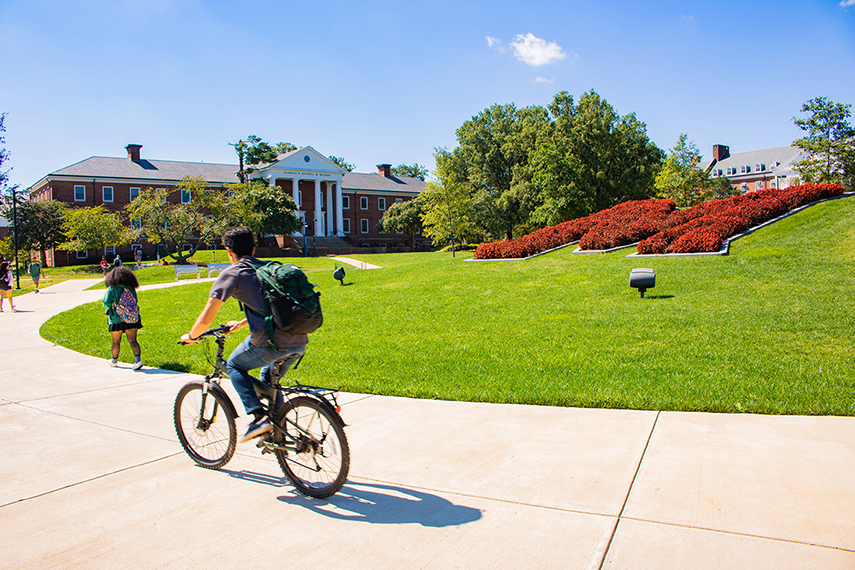 Person biking in front of the "M".