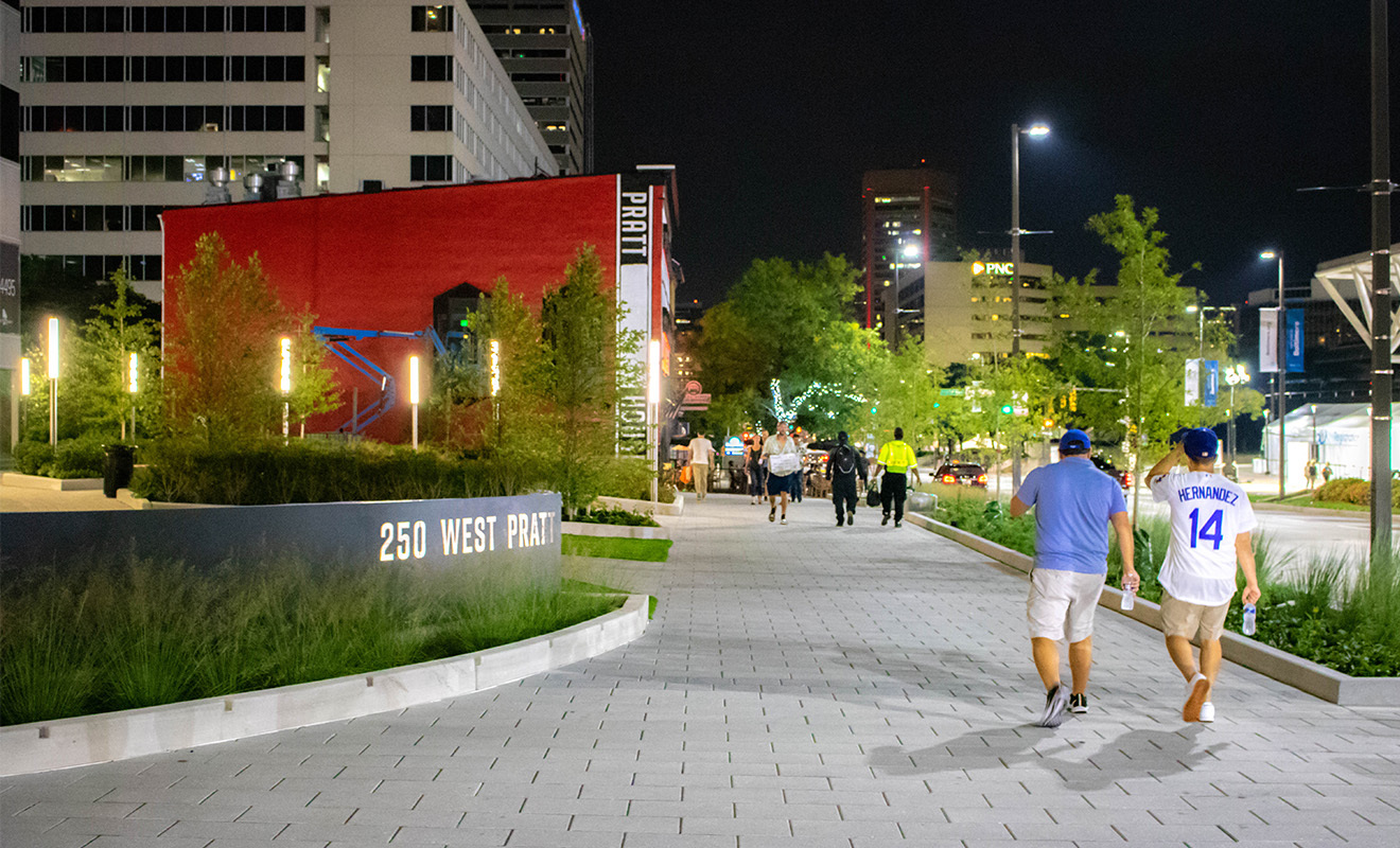 Baseball fans walking through plaza at night